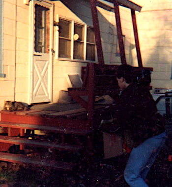 Tim bringing a box to the back porch, which is mentioned in this post.